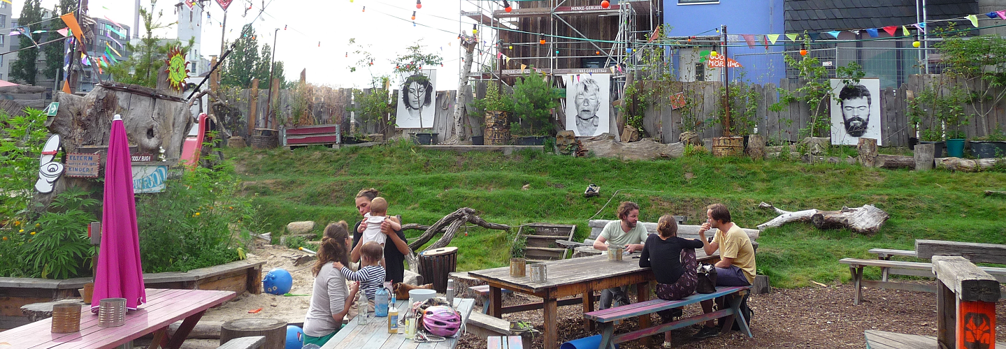 Menschengruppe im Gespräch auf Bänken am Holzmarkt in Berlin