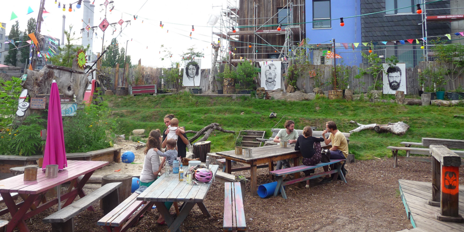 Menschengruppe im Gespräch auf Bänken am Holzmarkt in Berlin