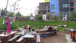 Menschengruppe im Gespräch auf Bänken am Holzmarkt in Berlin