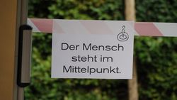 Ansicht eines Schildes mit Aufschrift "Der Mensch steht im Mittelpunt"