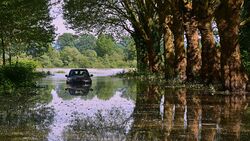 Auto auf überschwemmter Straße