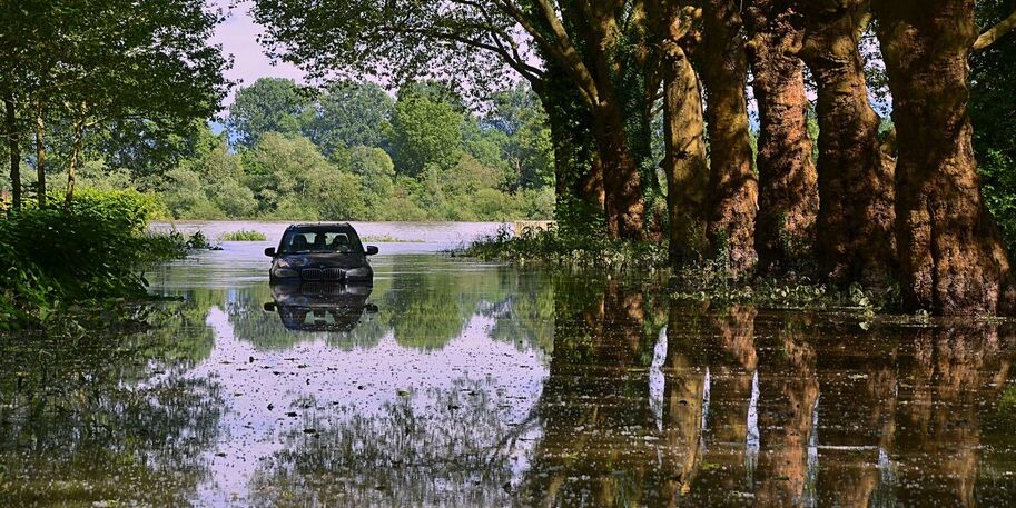 Auto auf überschwemmter Straße